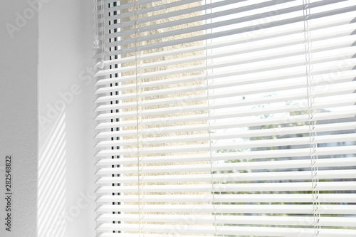 Window with open modern horizontal blinds indoors, closeup