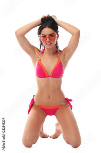Beautiful young woman in stylish bikini with sunglasses on white background © New Africa
