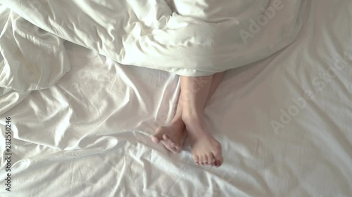 The legs of the girl who moved on the white mattress comfortably photo