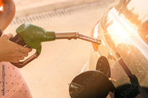 Car gas nozzle refuel fill up with petrol gasoline at a gas station.  Transportation and ownership concept