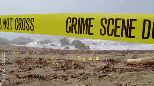 FOGGY BEACH CRIME SCENE, WITH POLICE TAPE AND EVIDENCE MARKERS.  4K, 10 BIT SLIDER SHOT.  NO PEOPLE.