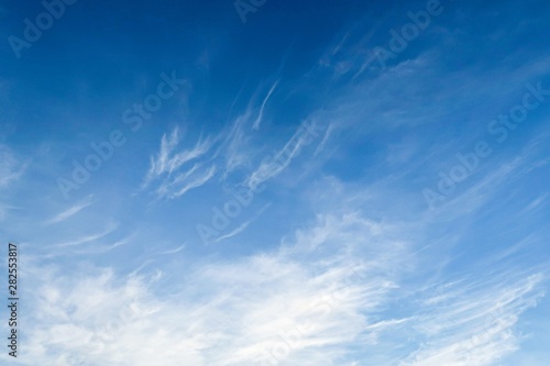 Dramatic unusual radiation explosion shaped clouds on tropical summer blue sky background. White wispy fluffy cloud with circus formation on tropical summer island sky in early sunlight morning 