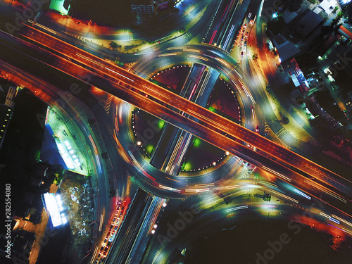 Aerial view of Circle Road traffic in roundabout and highway at night. Expressway, Modern transportation, Multilevel junction highway, Important infrastructure of transport in Thailand, Top view.