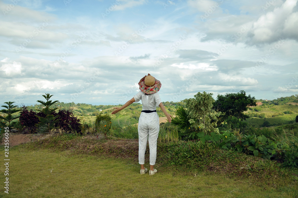 A happy woman enjoying the grasslands and mountains A happy woman enjoying the grasslands and mountains