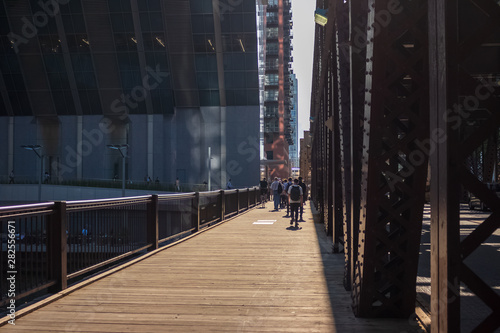Commuters walk in the bright sunlight on the Lake St bridge over the Chicago River in the Loop