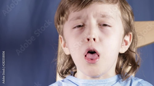 Coughing boy of six years old. Closeup photo