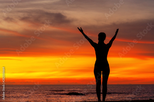 strong confidence woman open arms under the sunrise at seaside