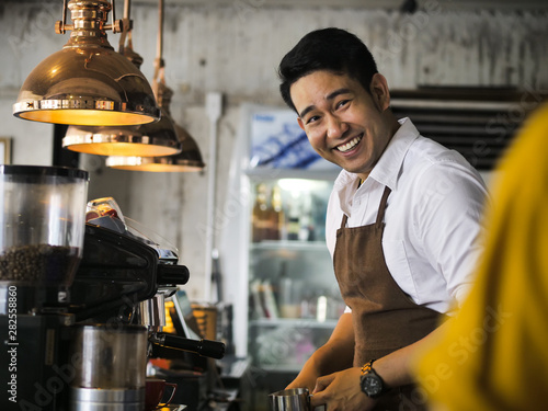 Happy Asian barista man working in cafe, lifestyle concept.