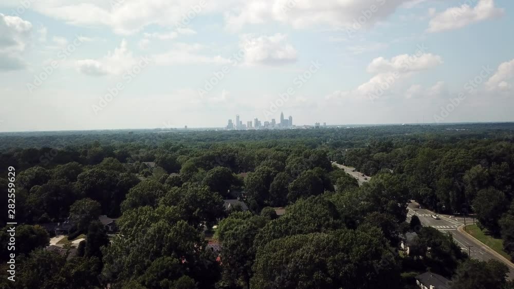 Aerial view of Charlotte NC Skyline in the distance as drone pushes forward Aerial view of Charlotte NC Skyline in the distance as drone pushes forward