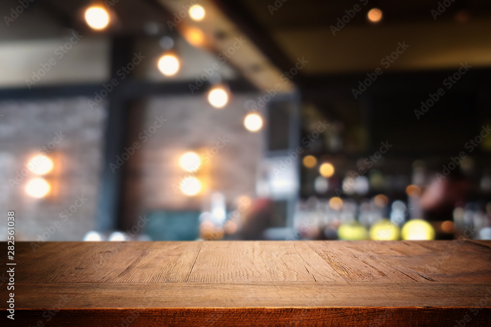 background Image of wooden table in front of abstract blurred restaurant lights background Image of wooden table in front of abstract blurred restaurant lights