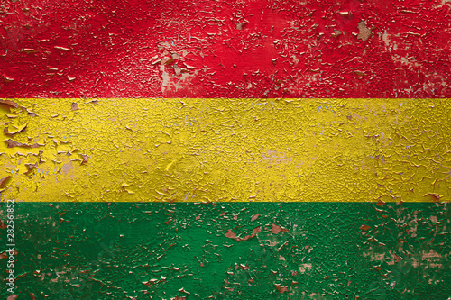 National flag of Bolivia on old peeling wall background.The concept of national pride and symbol of the country.