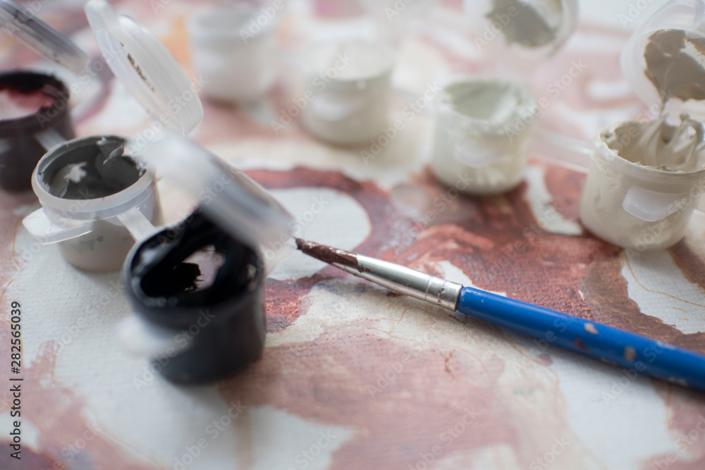 colored paint with a brush of the artist on the background of the painting