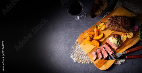 rustic medium butter beef steak with herbs and potato wedges photo