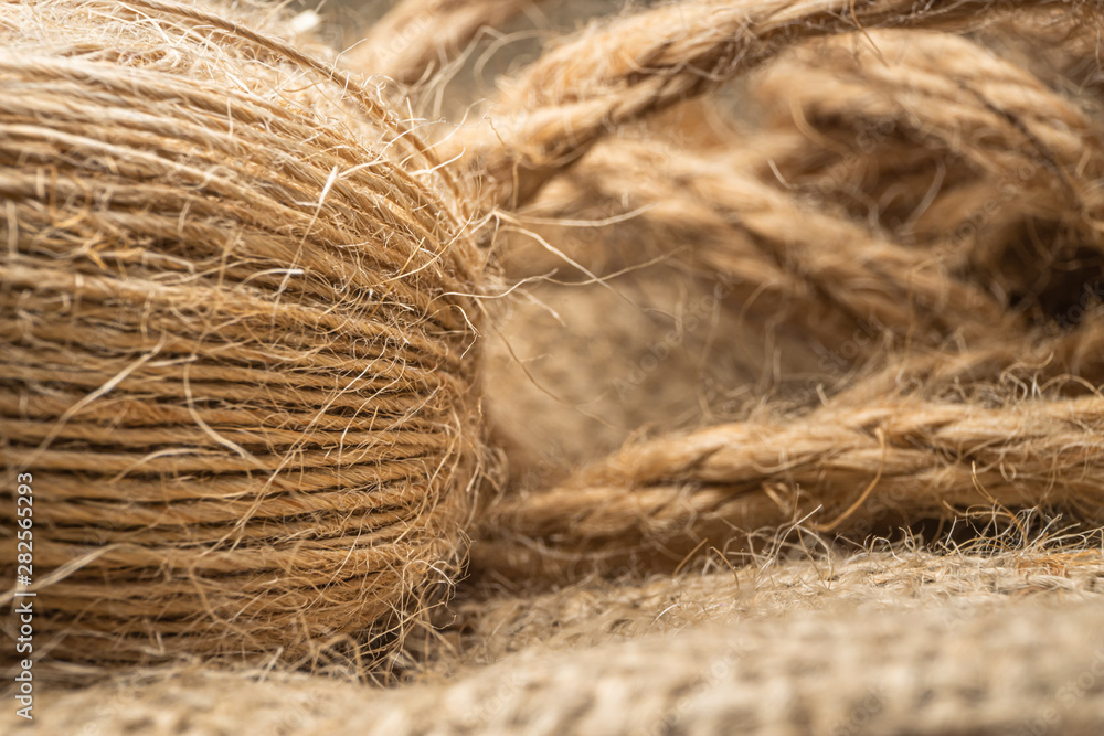 Macro view with natural jute twine roll isolated on natural linen fabric Macro view with natural jute twine roll isolated on natural linen fabric