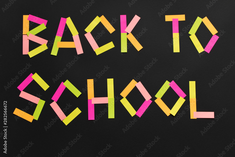 The inscription Back to school from the colored stickers on the blackboard. The inscription Back to school from the colored stickers on the blackboard.