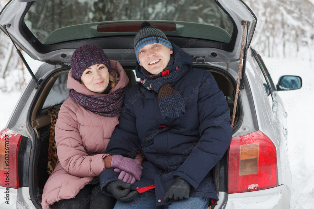 Loving married couple sit in the car in the winter. Loving married couple sit in the car in the winter.