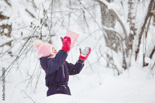 Young girl in the winter snowy forest.