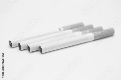 cigarettes stacked on a white background black and white photography 