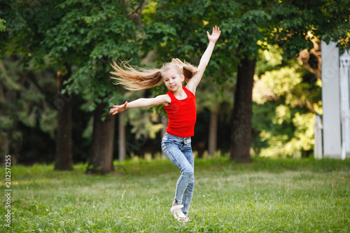Teen girl in a jump in a city park.