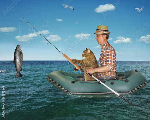 The fisherman im a straw hat with his cat is fishing in the rubber boat in the sea. They caught a big fish.
