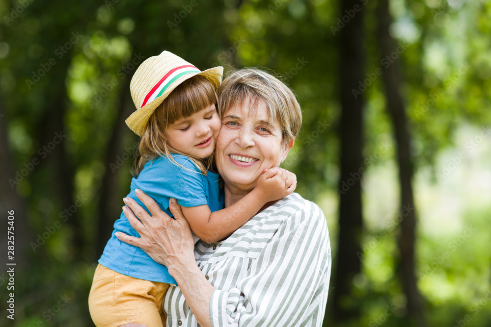 Happy grandmother with her grandchild  spend time together in the summer outdoors.