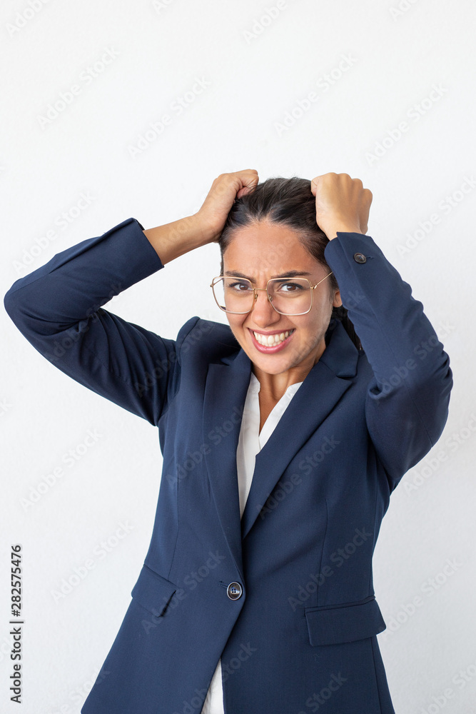 Nervous young businesswoman. Scared young business woman touching head and looking at camera isolated on grey background. Stress concept Nervous young businesswoman. Scared young business woman touching head and looking at camera isolated on grey background. Stress concept