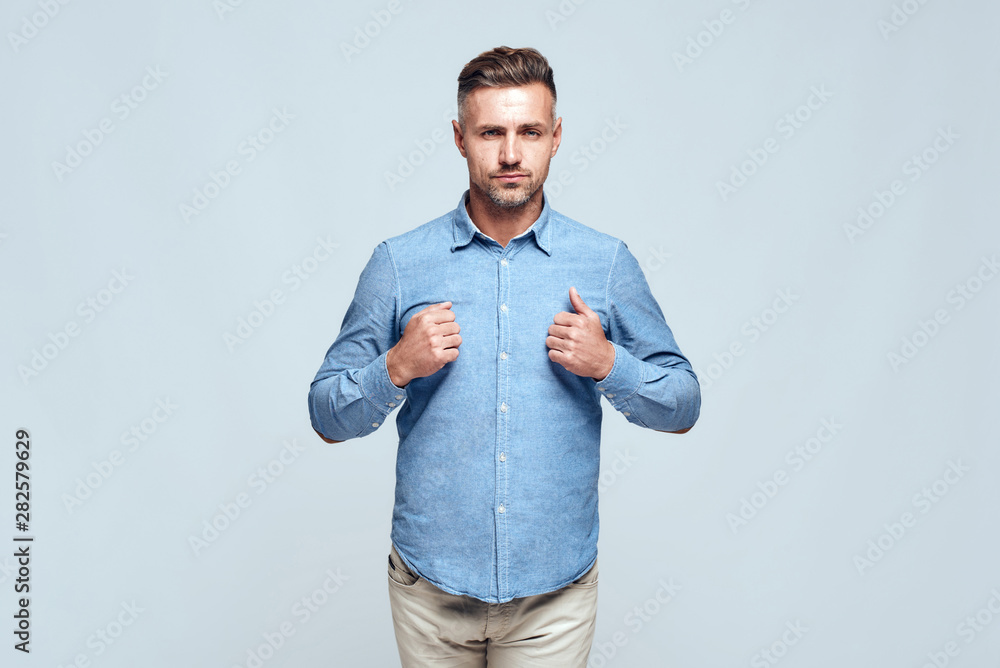 I can do everything. Confident and handsome man in casual clothes with closed fists near the chest standing against grey background I can do everything. Confident and handsome man in casual clothes with closed fists near the chest standing against grey background