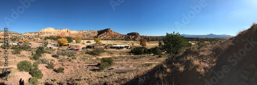 Desert panorama of a lodge in Ghost Ranch, surrounded by expansive mountains 