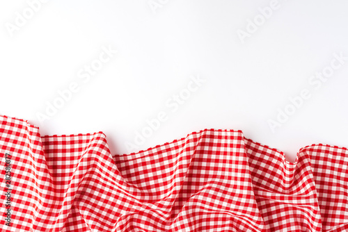 Gingham cloth on white background with copyspace. Top view