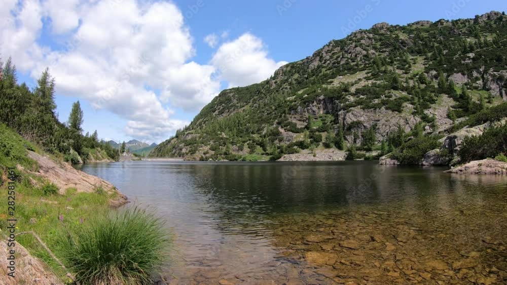 Italian Alps. Italy. Wonderful time lapse of an alpine lake created by the dam barrier. Orobie Alps. Summer time