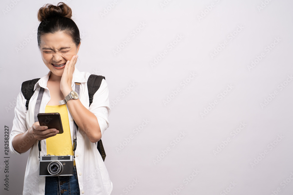 Tourist woman holding smartphone isolated over white background Tourist woman holding smartphone isolated over white background