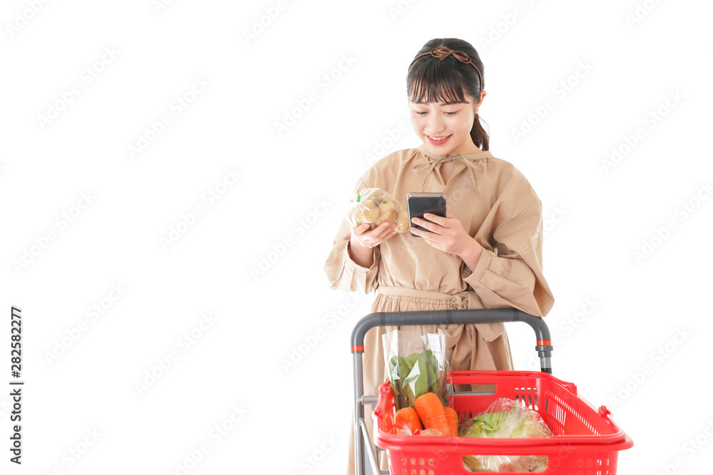 スーパーで食品の原産地を調べる若い女性 スーパーで食品の原産地を調べる若い女性