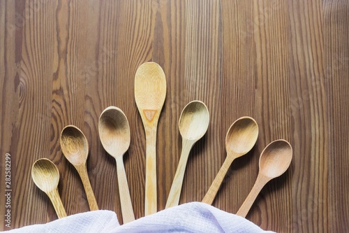 Wooden spoons on a vintage wooden background. Flat lay, top view, copy space.