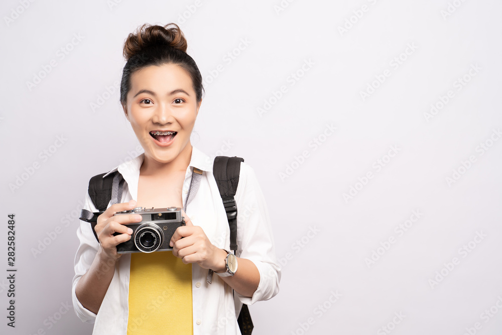 Happy woman holding camera over background and looking at camera Happy woman holding camera over background and looking at camera