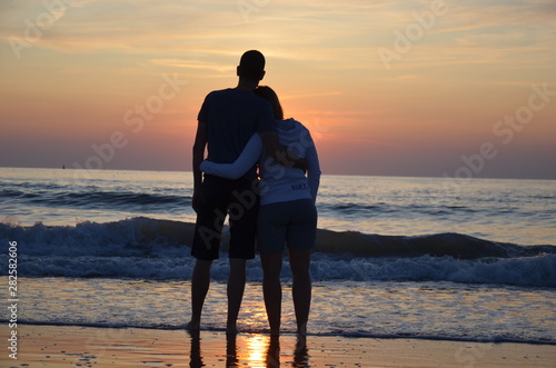 Couple amoureux devant un couché de soleil sur la plage photo