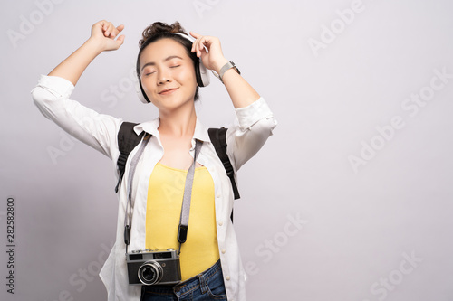 Tourist woman listening music isolated over white background