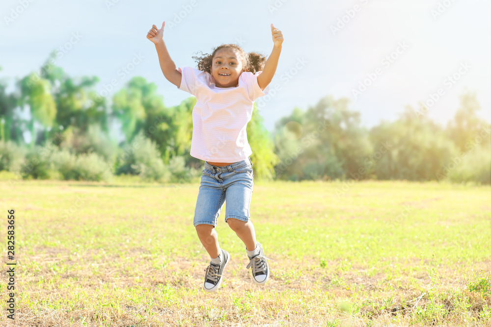 Jumping African-American little girl outdoors Jumping African-American little girl outdoors