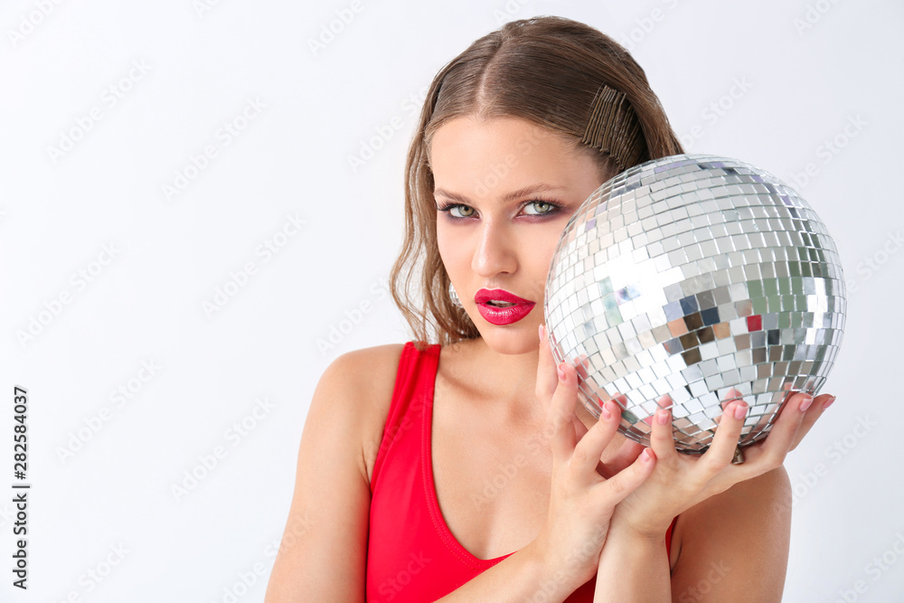 Fashionable young woman with disco ball on white background Fashionable young woman with disco ball on white background
