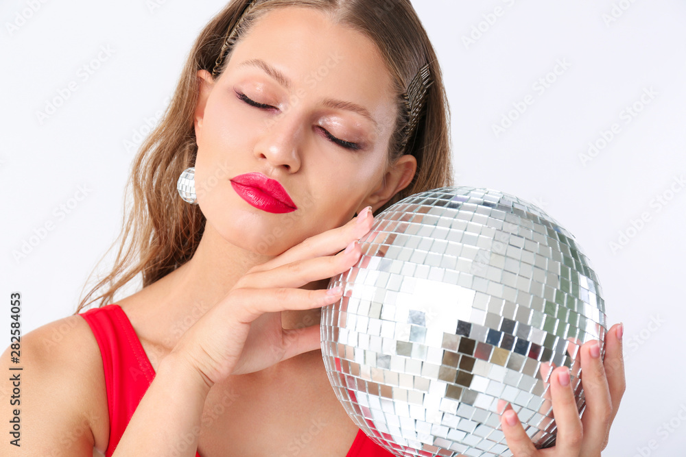 Fashionable young woman with disco ball on white background Fashionable young woman with disco ball on white background