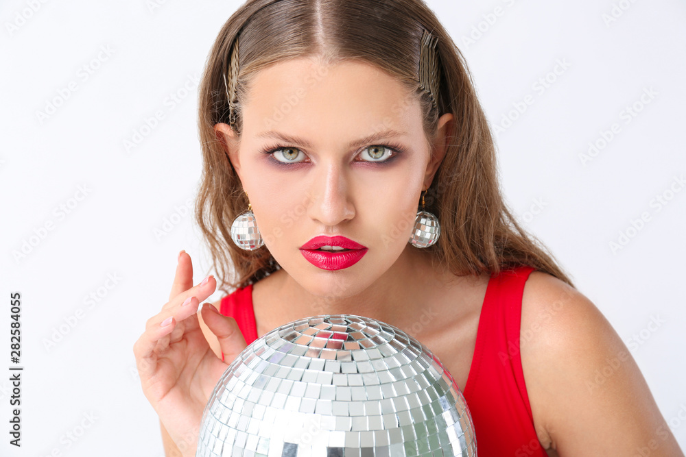 Fashionable young woman with disco ball on white background Fashionable young woman with disco ball on white background