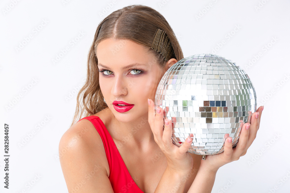 Fashionable young woman with disco ball on white background Fashionable young woman with disco ball on white background