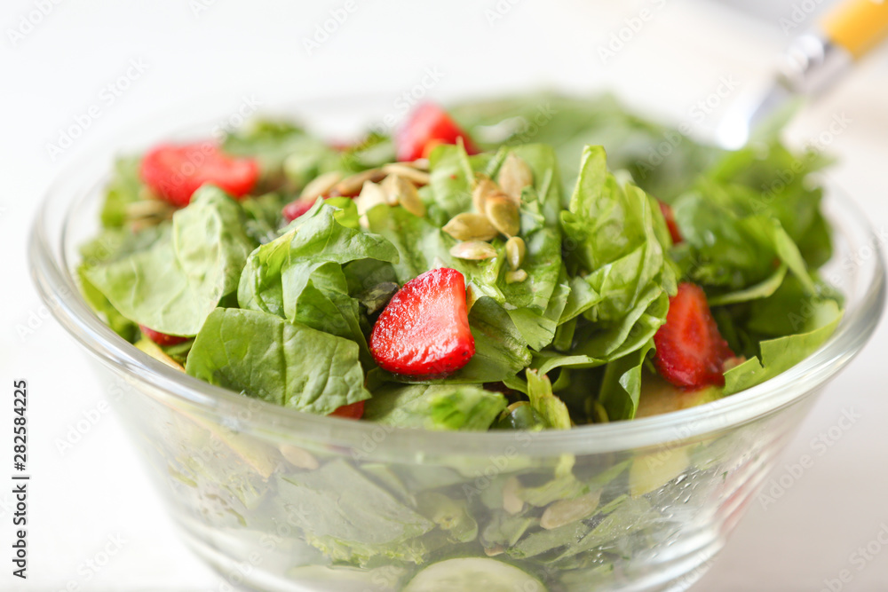 Bowl with fresh tasty salad on table, closeup Bowl with fresh tasty salad on table, closeup