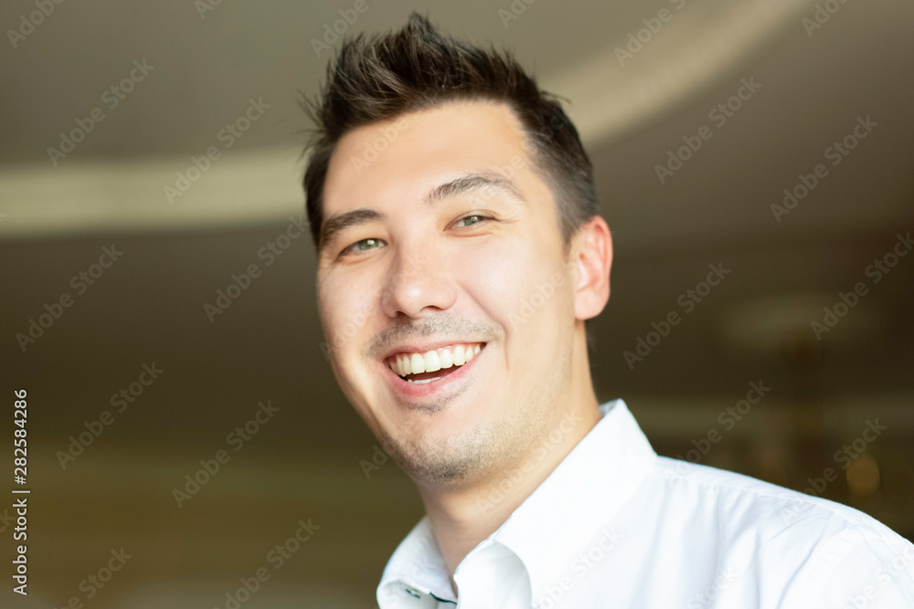 handsome young man smiling looking at camera in office handsome young man smiling looking at camera in office