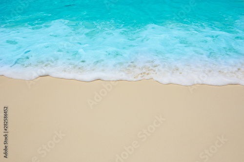 Soft waves of blue sea on the Maldives beach for the background.