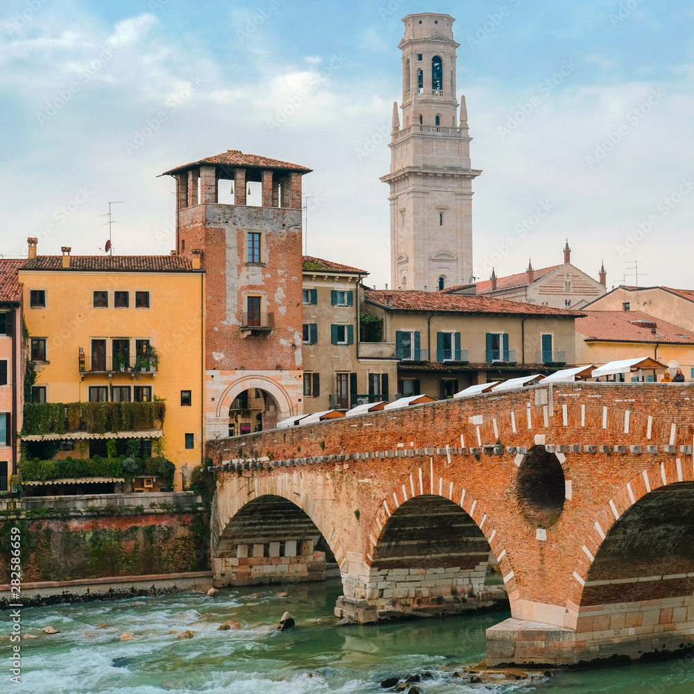 Fototapeta premium Roman arch bridge over Adige River in Verona. Historical center of European city. Romantic sightseeng trip to Italy