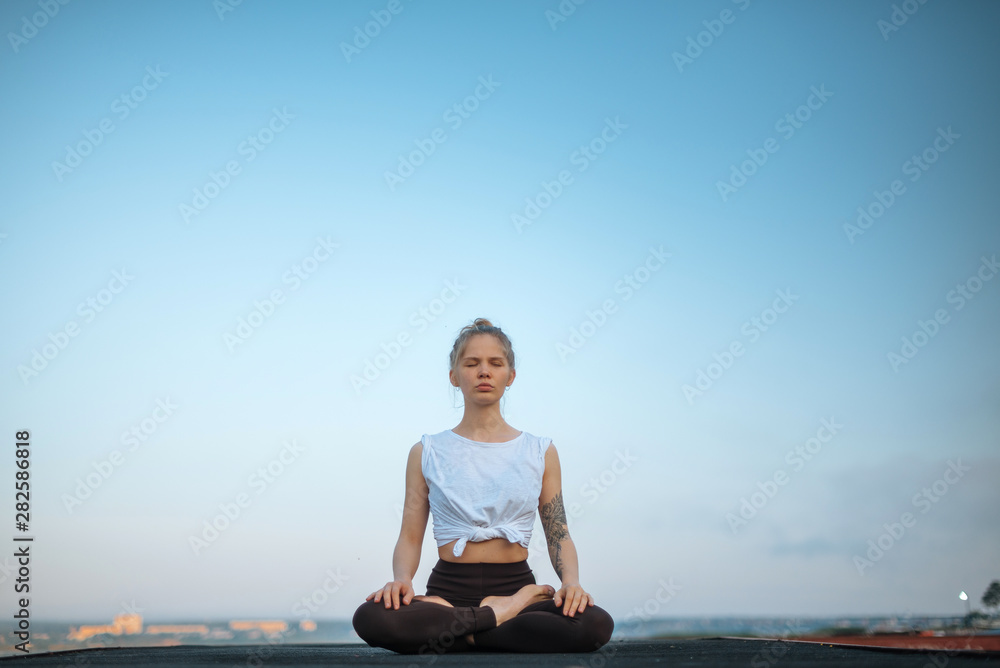 Fototapeta premium Girl practice yoga early morning on pier