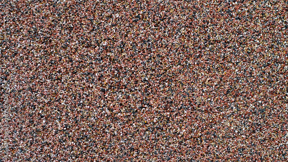 texture of a colorful sand wall with red, brown dark sandstones texture of a colorful sand wall with red, brown dark sandstones
