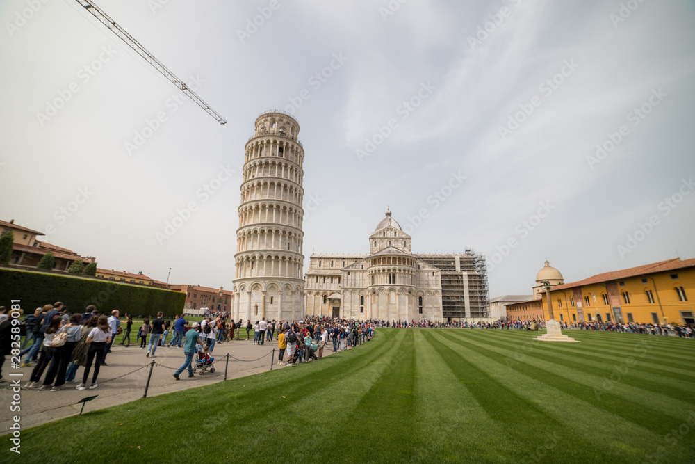 Tourists walking near the leaning tower of Pisa
