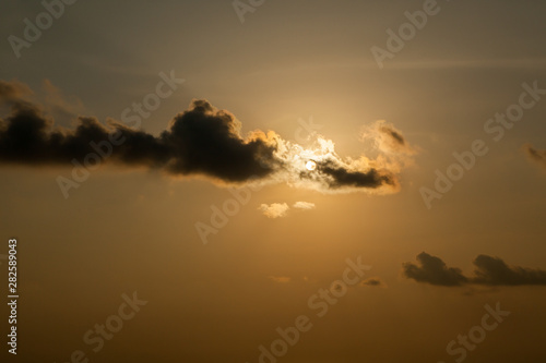 sun at sunset obscured by clouds at Thailand. © wandee007