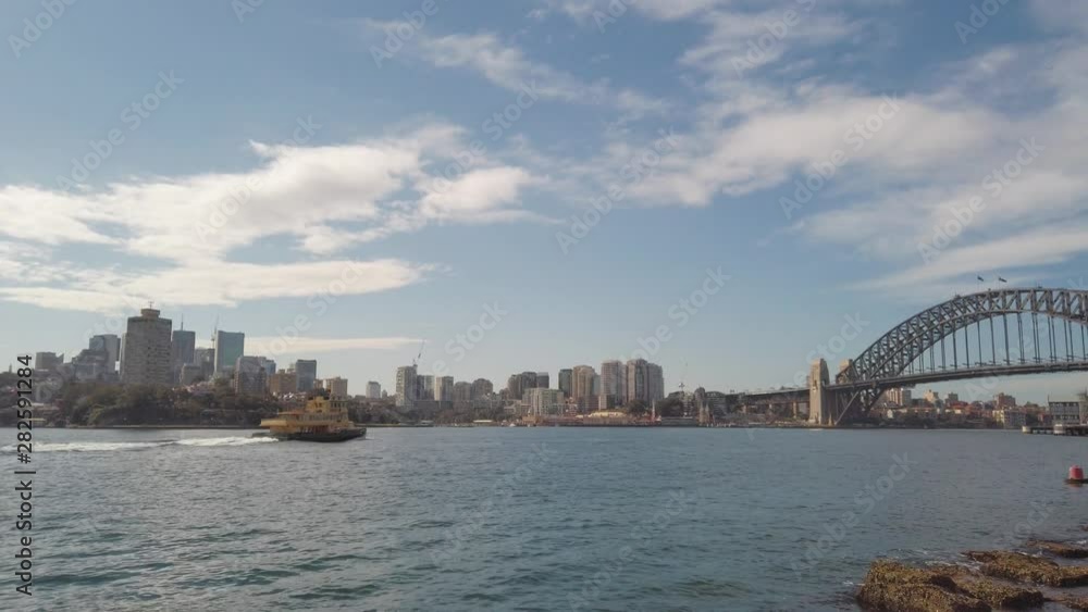 A ferry heading towards Harbour Bridge. View from a park in Sydney Australia. A ferry heading towards Harbour Bridge. View from a park in Sydney Australia.